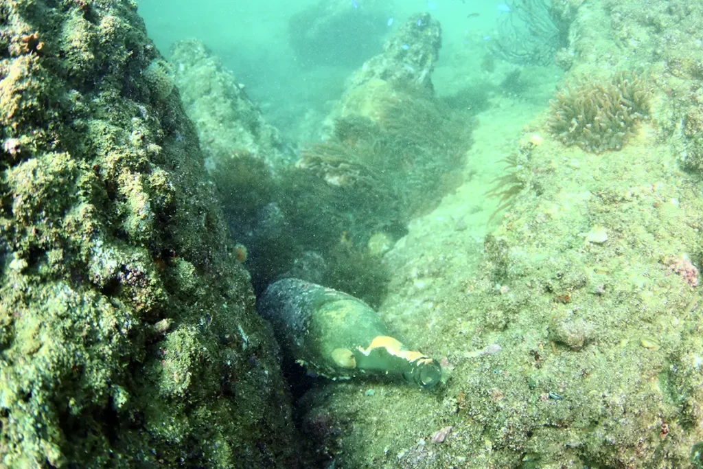 ダイビング中に海底で発見した空き瓶のごみ