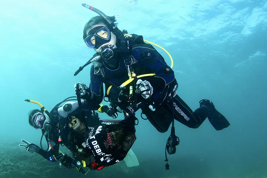 バディで海ごみを回収するダイバー