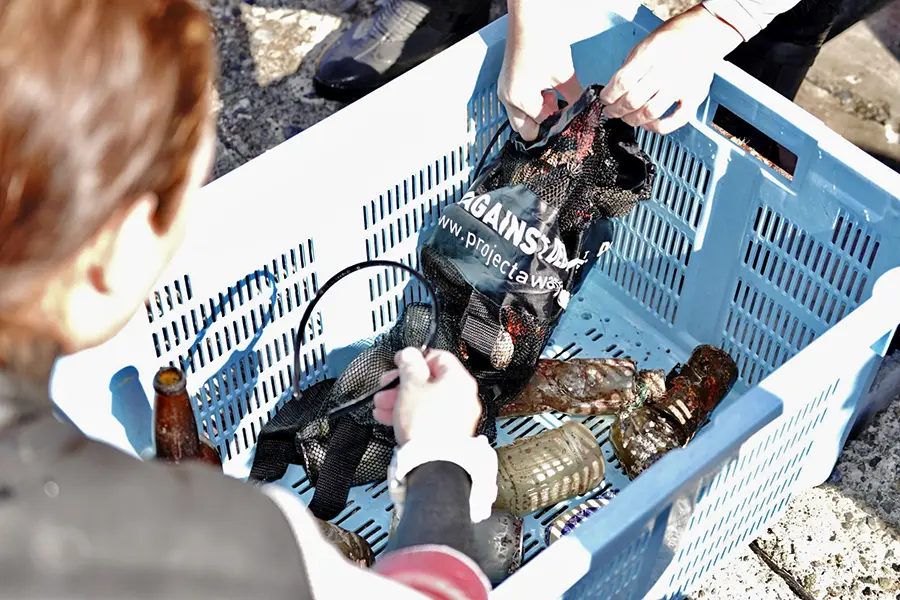 ダイブアゲインストデブリで回収した海ごみを分類するダイバー